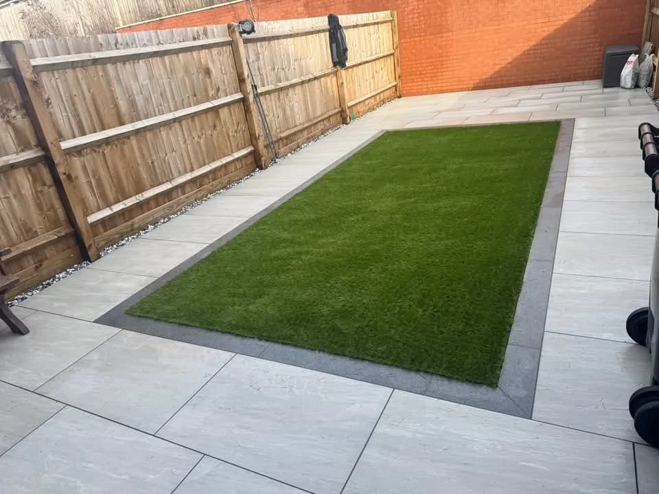 Porcelain patio framing a new artificial grass lawn by Akromis